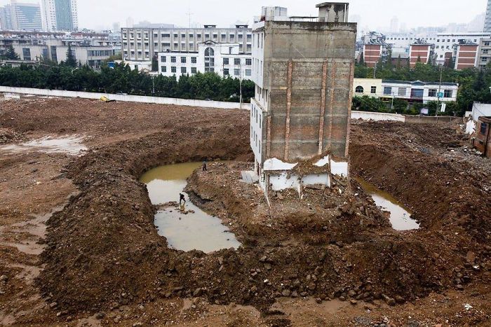 中國昆明這棟公寓樓的租客，承包商挖了一道溝，迫使最後一個家庭出來，必須經過一個護城河。 