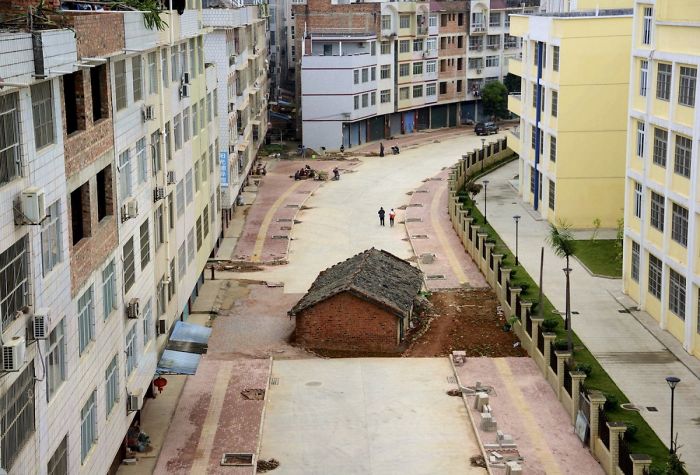 位於中國南寧的一座正在施工的道路中間的一間美甲房屋，2015年4月。房屋所有者未能與當地政府達成協議，