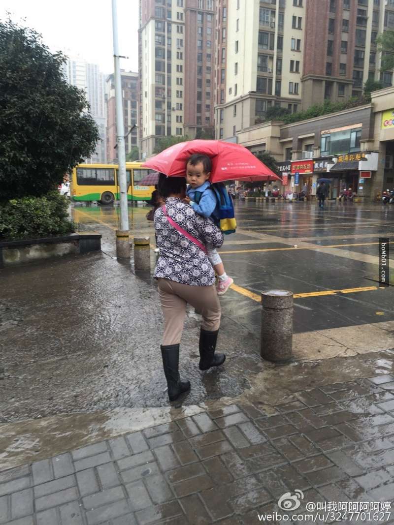 奶奶在下雨天为孙子打伞的照片一上传立马疯传