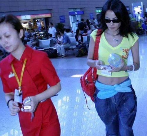 48歲王菲現身機場，露臍裝一片譁然，網友：絲巾當腰帶夠大膽！