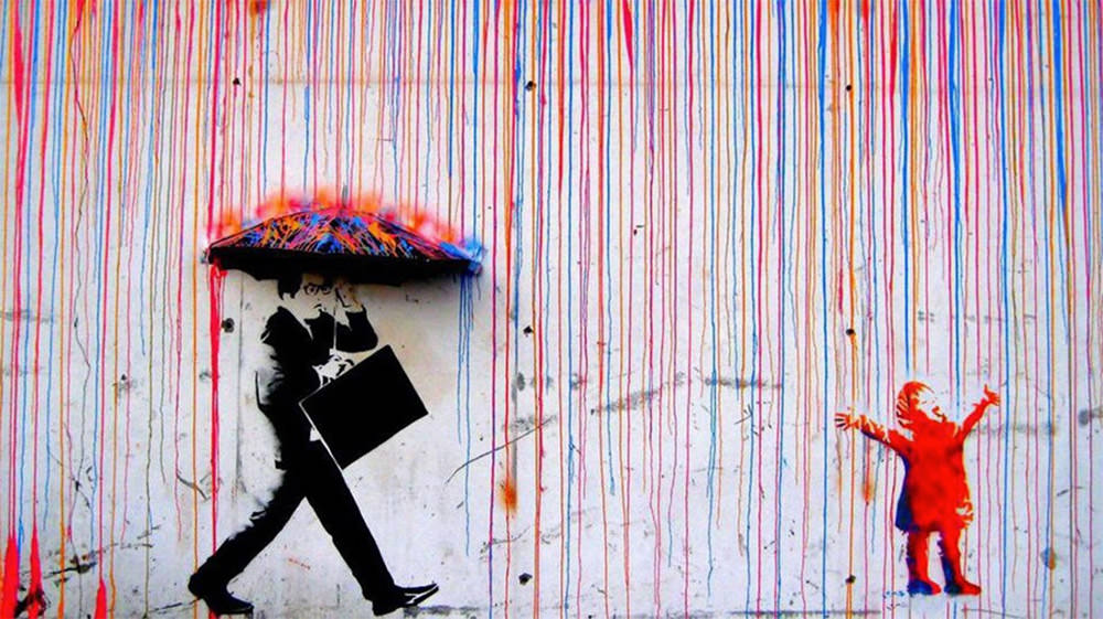 16 - Street art of a person walking with umbrella as boring black and white while the person standing in the rain is full of color.