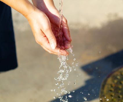 Water Pouring on Person's Hand