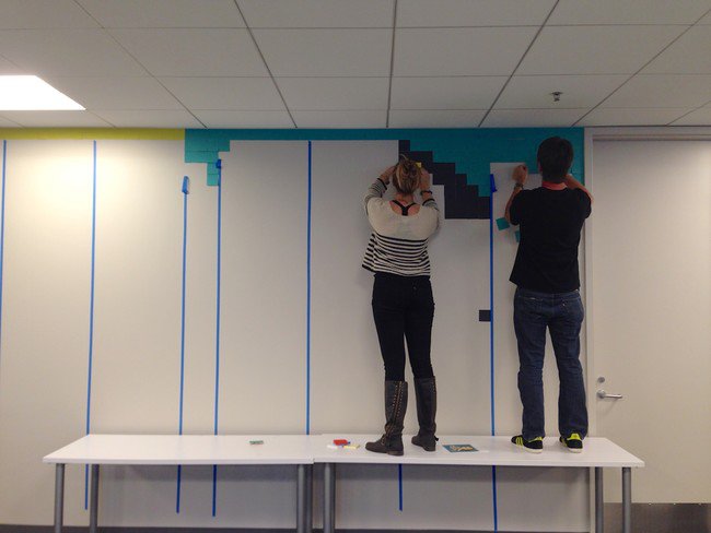 The colleagues gathered on a Saturday for the installation. The borders were marked out with tape, and the application of the Post-Its began.
