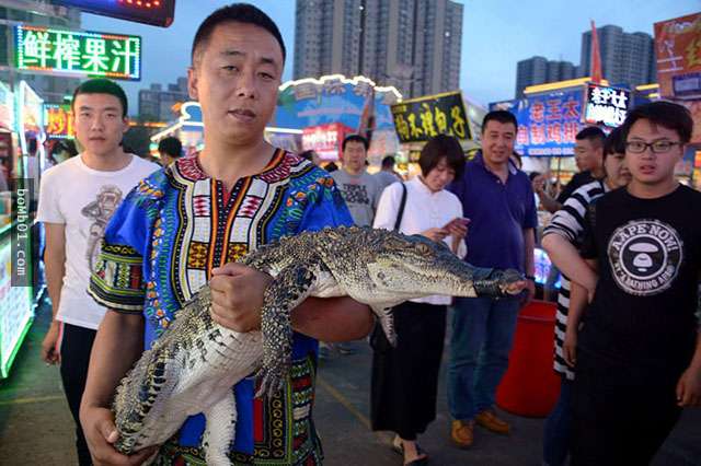 老板把一整只的鳄鱼放到摊位上后立马吸引人潮,知道价钱时大家都担心