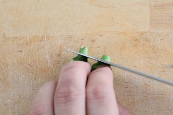 料理秋葵時，先以小刀切除上方的蒂頭。
