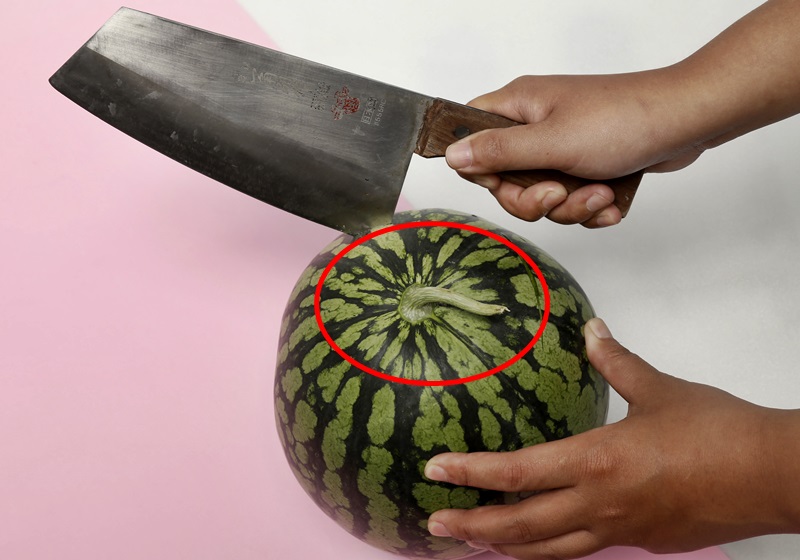 先用菜刀略将西瓜的外皮上半部切一圈,让西瓜的张力释放,使大气压力