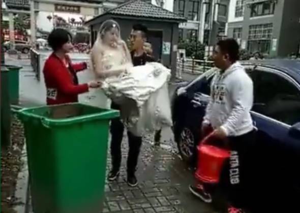 新郎抱新娘下車，不料鞭炮聲太大，新郎竟嚇得將新娘摔進了垃圾桶