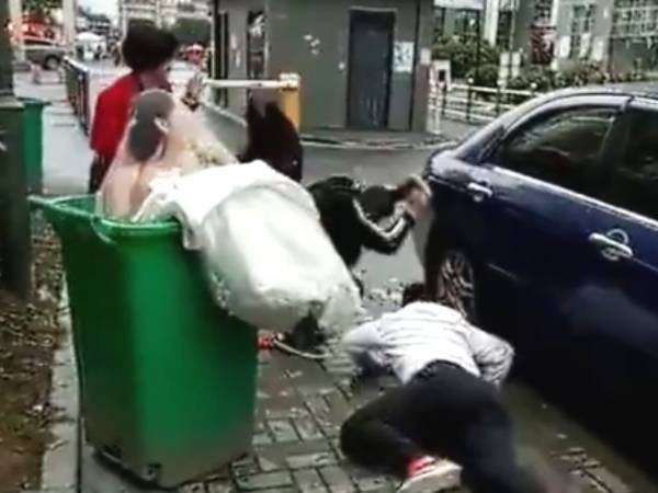 新郎抱新娘下車，不料鞭炮聲太大，新郎竟嚇得將新娘摔進了垃圾桶