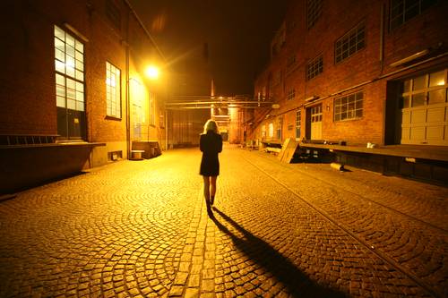 Woman Walking on Street at Night