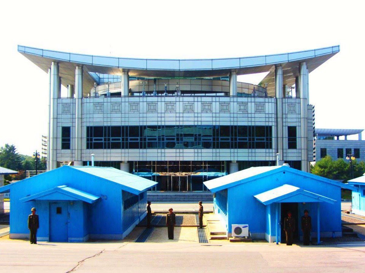 The South Korea/North Korea border starts at the concrete line between the blue huts here. Former President Bill Clinton called the area "the scariest place on Earth." 

Not surprising, since it's the most heavily militarized border in the world.